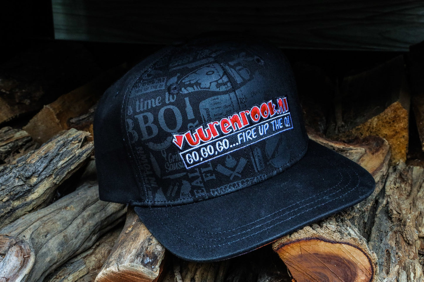 Zwarte limited edition snapback met kleurrijke 'Vuurenrook' print en BBQ-tema. Goudkleurige label op de klep en zichtbare 'Limited Edition 2022' badge voor BBQ-fans.
