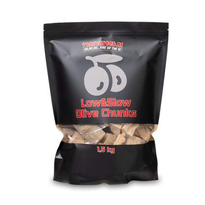Zwarte verpakking met transparante onderkant, gevuld met houtblokken voor barbecue. Product 'Low&Slow Olive Chunks' van 1,5 kg, geschikt voor slow-cook en grillen.