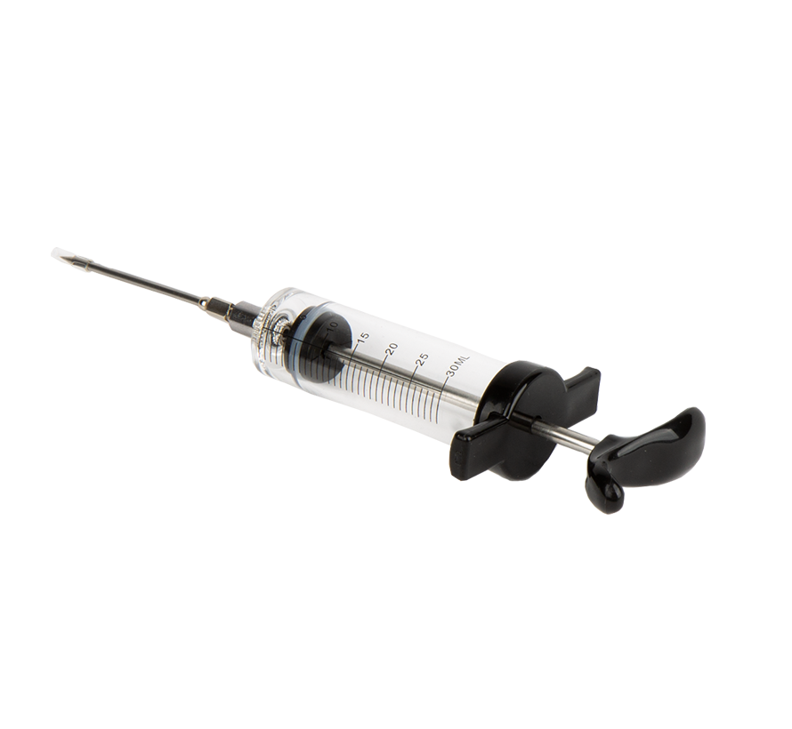De Meat Injector is een transparante, glazen spuit met metalen naald, verpakt in zwart blisterpapier met rood logo. Geschikt voor vleesinjectie bij barbecue en grillen.