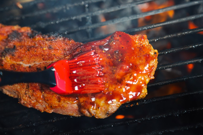 Rode siliconen borstel met zwarte handvat, bedoeld voor het aanbrengen van olie op grill of brood. Geschikt voor kookgereedschap en grilltoepassingen.