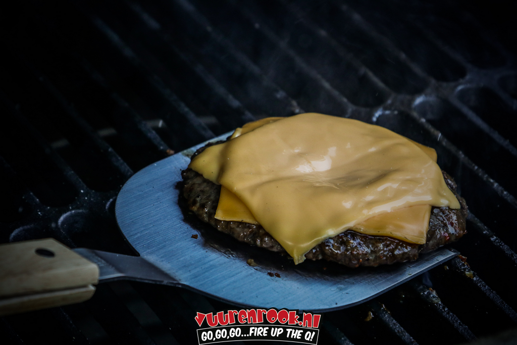 Een zilverkleurige, xtra lange roestvrijstalen burgerflipper met houten handvat, verpakt in zwarte blister. Geschikt voor grillen en koken op de barbecue.
